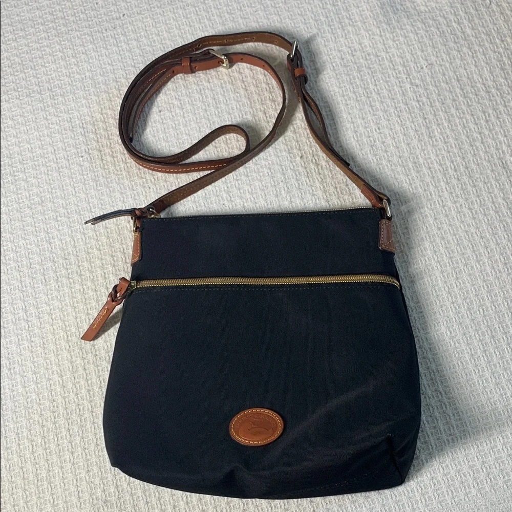 Dooney & Bourke black nylon crossbody bag with brown leather strap and accents